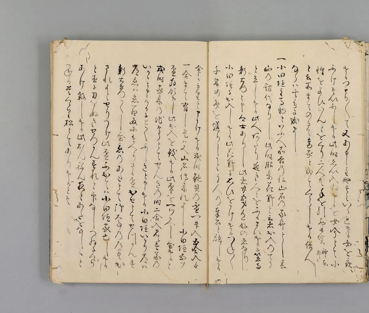 Two facing pages of a Japanese manuscript in flowing brush script, the right page beginning with a bold stroke that marks a new entry